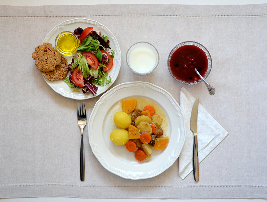 Kuvassa karjalan juures-lihapata, perunat, vihreä salaatti, porkkanarieskaset, maito/piimä, hedelmäsalaatti
